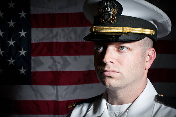 caucasico naval officer davanti bandiera americana - naval flag foto e immagini stock