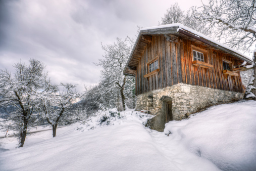 Rustic cabin on a snow-covered farm in the Alps.  