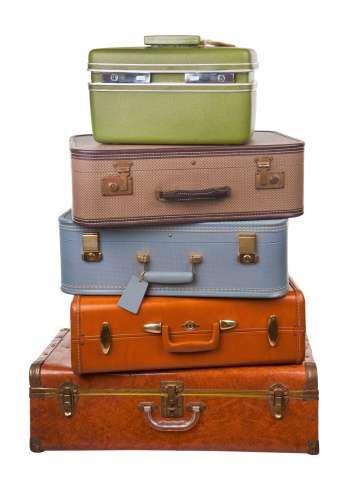a stack of older assorted luggage pieces isolated on white