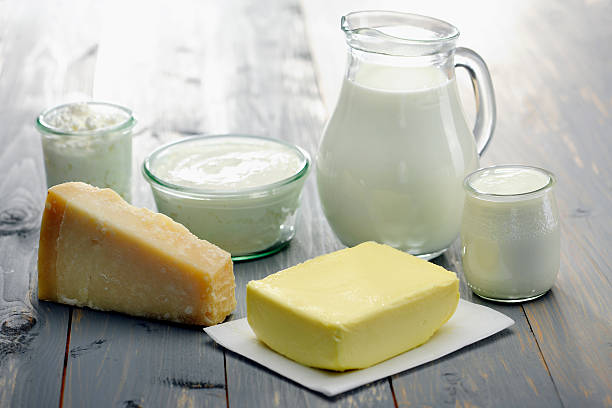 Jug of milk with pat of butter yoghurt and cheese stock photo
