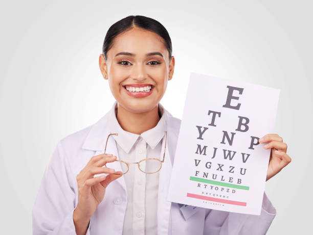 portrait, glasses and eye test with a woman optician in studio on a gray background for vision or eyesight. face, smile and a happy young doctor in a clinic or optometry office for a medical exam - telephone doctor medical exam healthcare and medicine imagens e fotografias de stock