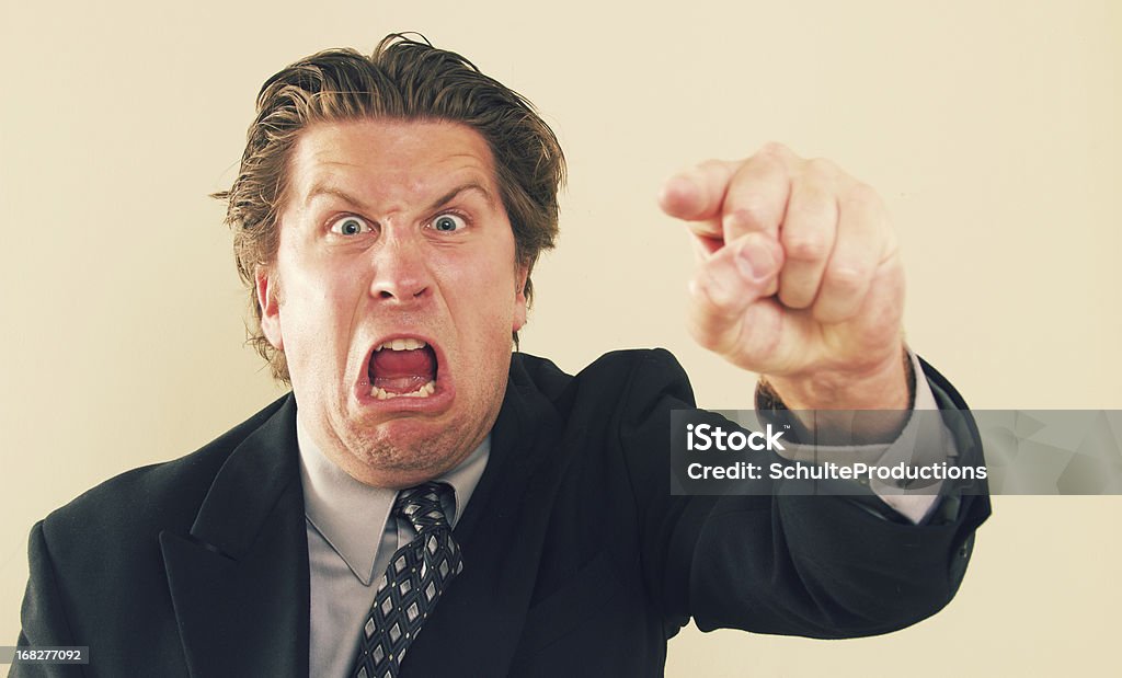 Bossy Man a bossy businessman pointing and screaming. Anger Stock Photo