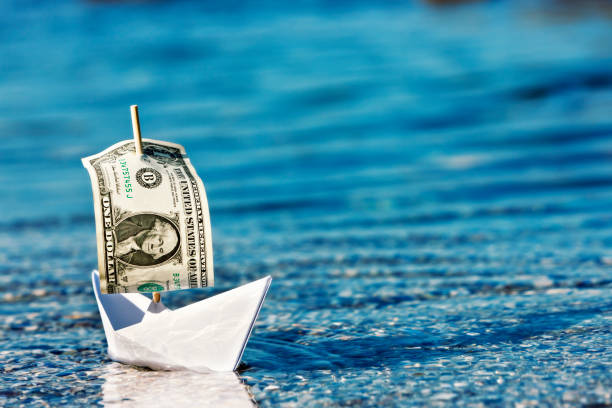 istock Floating a company? Paper boat with dollar bill sail 168277426