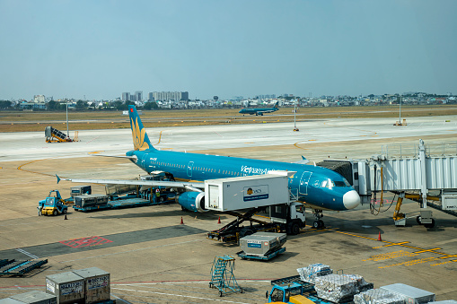 Ho Chi Minh City, Vietnam - March 30, 2019: Vietnam Airlines flight is loading in Ho Chi Minh Airport for its next flight and another far away flight is preparing to fly.