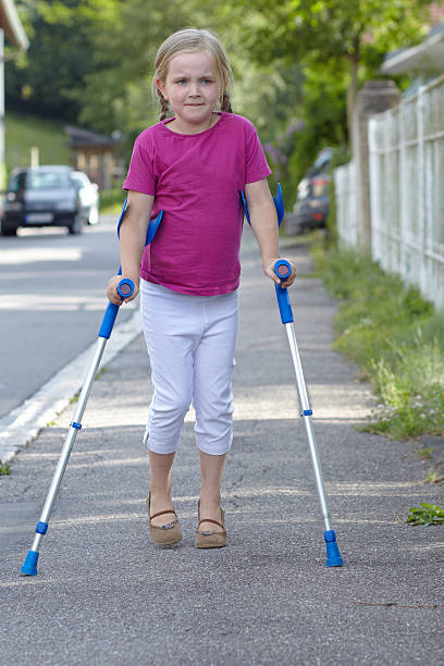 Little girl with crutches stock photo