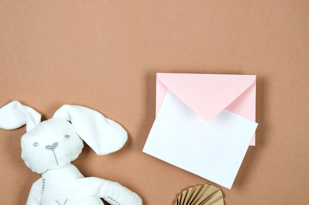 istock Pink envelope with empty white card for text and white plush bunny on beige background 1682781947