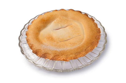 Studio shot of a fruit pie resting on a glass plate cut out against a white background