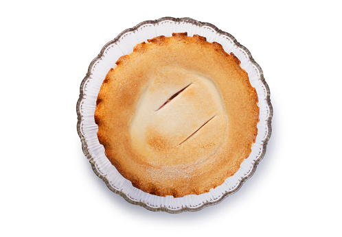 Overhead shot of a fruit pie resting on a glass plate cut out against a white background