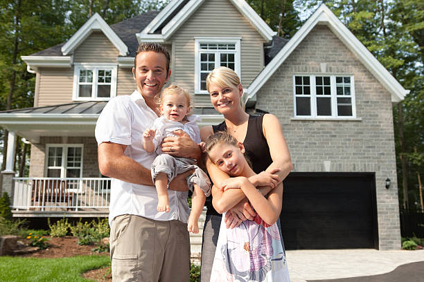 Happy Family In Front Of Their New House Happy Family In Front Of Their New House. in front of stock pictures, royalty-free photos & images