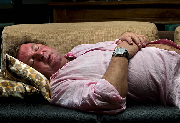 sun Caucasian overweight mature man taking a nap in a sofa (this picture has been taken with a Hasselblad H3D II 31 megapixels camera) hairy fat man pictures stock pictures, royalty-free photos & images