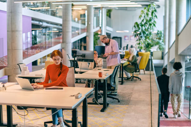 In a modern startup office, a diverse group of young professionals collaboratively tackles various business problems and challenges, surrounded by their engaged colleagues, fostering innovation and productivity
