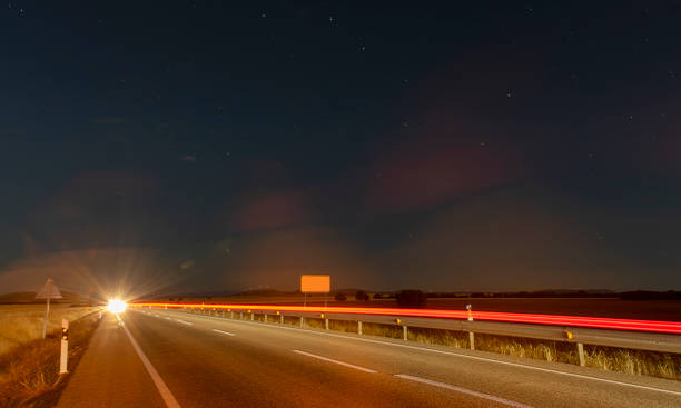 istock Captivating Nighttime Highway Drive: Starlit Sky and Light Trails 1682812587