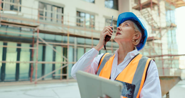 istock Construction site, walkie talkie and talking woman, architect and planning infrastructure, civil engineering or property innovation. Radio, industrial or contractor discussion on building development 1682816551