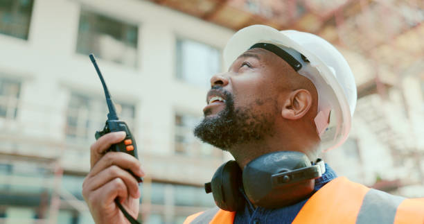 istock Building, radio and a black man construction worker on a site for project management or development. Communication, safety and an engineer talking on a walkie talkie for industrial architecture 1682816688