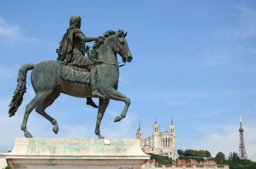 Equestrian statue of king Louis XIV at Bellecour Square in Lyon. Sculptor - François-Frédéric Lemot (1775-1827). Notre Dame cathedral and Eiffel Tower in foredround.