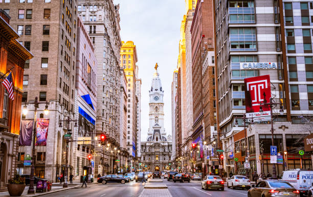 Philadelphia, USA - Pedestrians and cars on Broad Street in central Philadelphia at dusk.