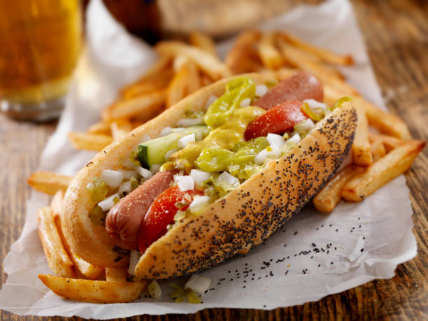 Classic Chicago Dog with Fries A Classic Chicago Dog with Fries and a Beer - The Chicago Dog has a Steamed Poppyseed Bun, Fresh Tomatoes, Diced Onions, Neon Green Relish,Peppers,Pickle, Yellow Mustard and a Dash of Celery Salt- Photographed on Hasselblad H3D2-39mb Camera relish stock pictures, royalty-free photos & images