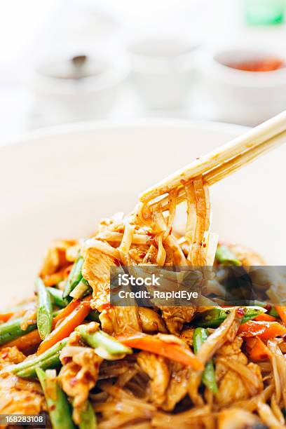 Bacchette Cinesi Che Saltati In Padella Con Pollo Thai Spaghetti In Una Ciotola - Fotografie stock e altre immagini di Carne di pollo