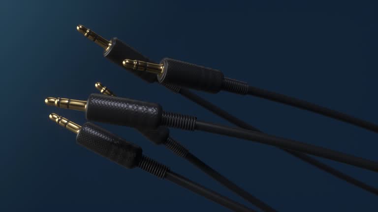 AUX cable spinning on dark blue background.Close-up view of the wire in high definition.Auxiliary connectors audio stereo for sound recording studio. Hi fi cord for musical equipment. Accessories