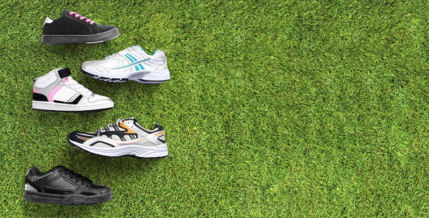 Group of running assorted athletic shoes for the family on a green grass