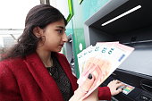 Young woman withdraws money from ATM