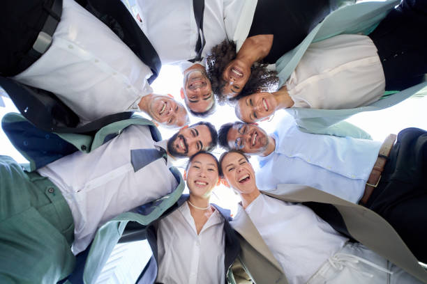 istock Multiracial diverse group office men women colleagues hugging in circle looking down smiling camera. 1682916833