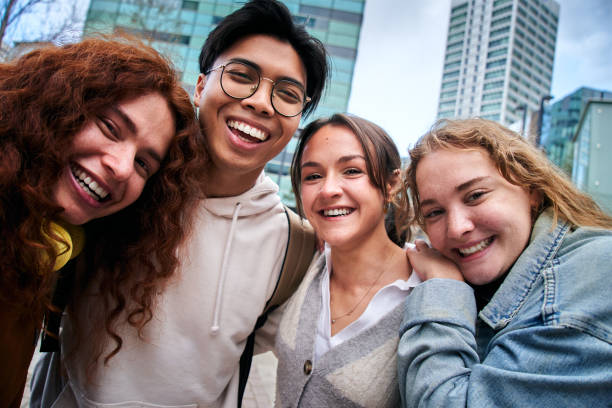 istock Portrait of a group of four cheerful multi ethnic students having fun outdoors taking smiling selfie 1682926267