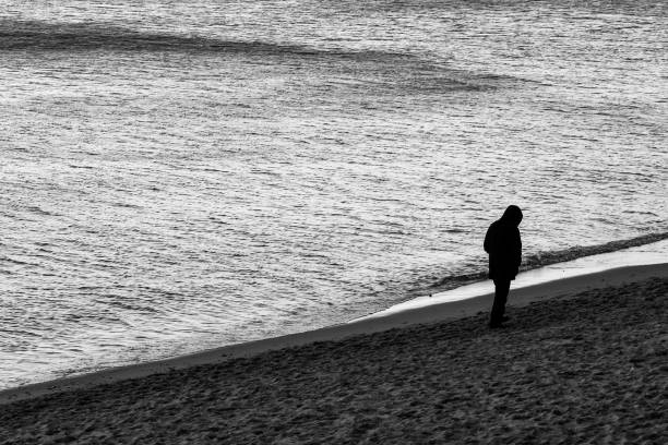 istock a lonely man walks on the beach 1682932199