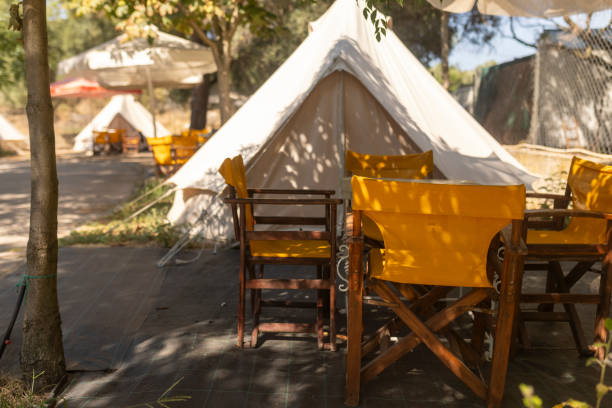 istock A sunlit camping tent with a table and chairs in front of it 1682941814