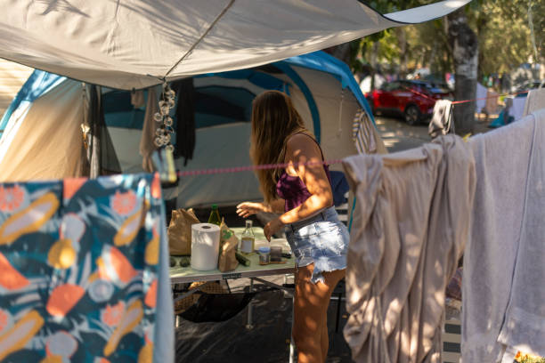 istock Woman drying laundry while camping on the beach by hanging it on a clothesline 1682941853