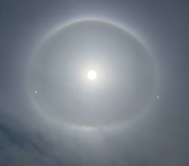 istock A halo is an optical phenomenon produced by light (typically from the Sun or Moon) interacting with ice crystals suspended in the atmosphere. Halos can have many forms, ranging from colored or white rings to arcs and spots in the sky. 1682942205