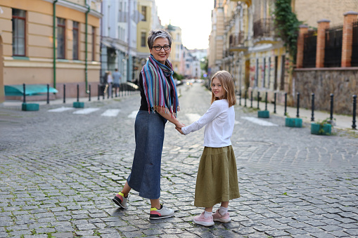 A mother and daughter walking together in the city, enjoying a day of leisure and togetherness.