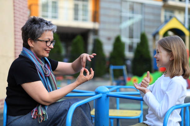 mujeres que enseñan lenguaje de señas a niños sordos, promoviendo la comunicación y la inclusión. - political rally fotografías e imágenes de stock