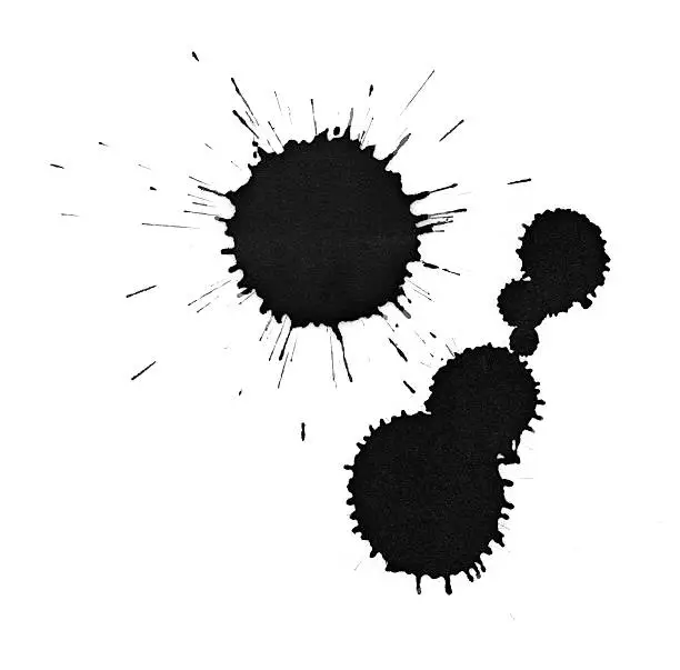 Photo of Black ink splatter drops close-up, isolated on white