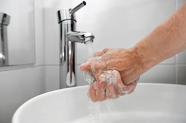 Soaping your hands under a faucet with the water falling