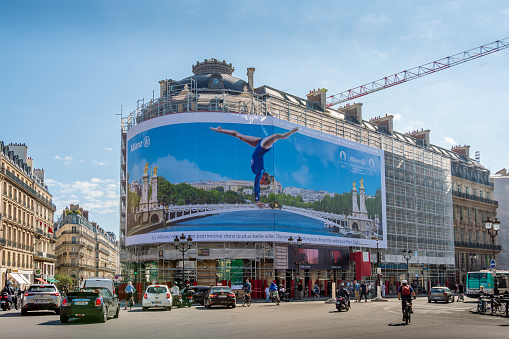 Paris, France - September 15, 2023: Giant advertising billboard sponsored by Allianz about the Paris 2024 Olympic games (gymnastics) on the scaffoldings of the restoration work of a parisian building