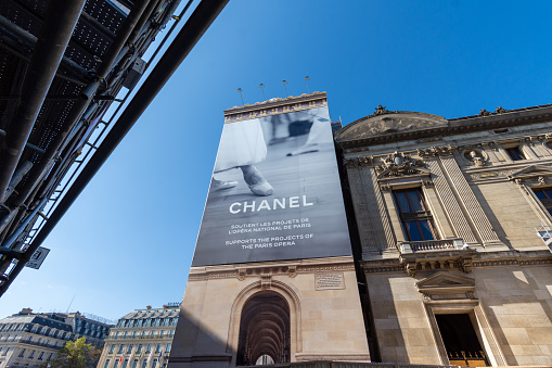 Paris, France - September 15, 2023: Chanel large advertising billboard covering the scaffolding of the restoration work on the facade of the Paris Opera house (Palais Garnier)