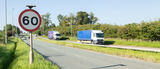 fast moving heavy goods vehicle passes a speed restriction sign