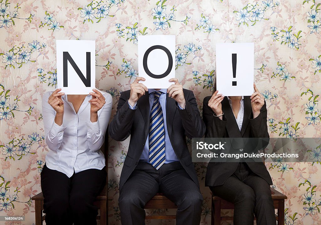 Three people holding the word NO! over their faces Judges holding up No sign Rejection Stock Photo