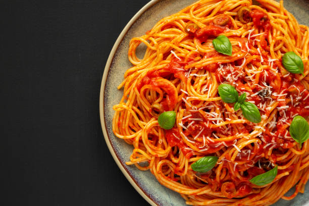 istock Homemade Spaghetti with Olives and Tomato Sauce on a Plate, side view. Copy space. 1683062019