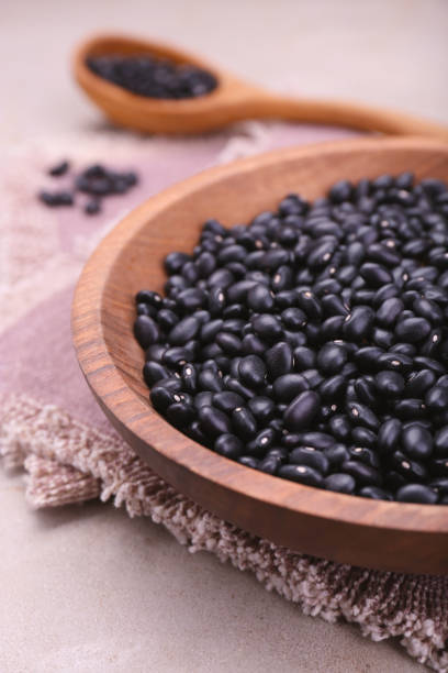 istock Bowl of raw black beans on light grey table, closeup 1683067968