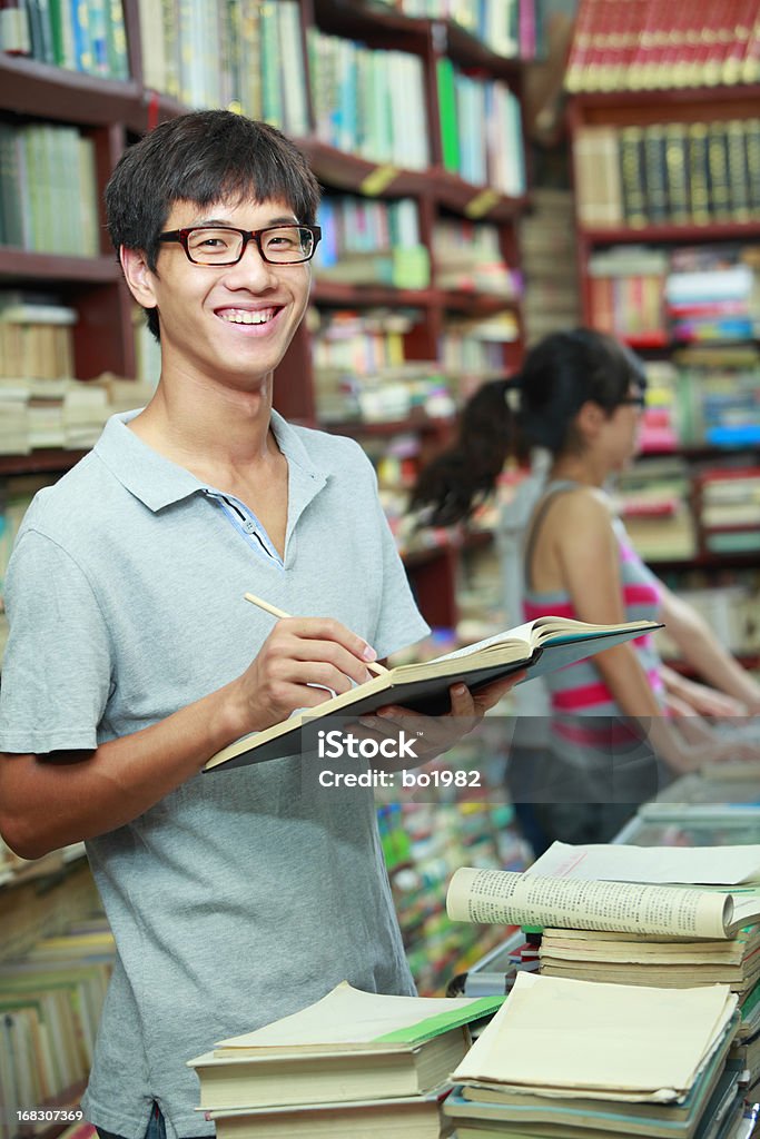 Ritratto di giovane Collegio studente nella Libreria - Foto stock royalty-free di Biblioteca