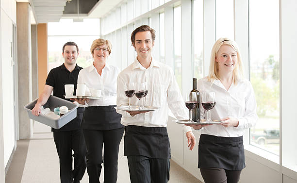 Wait Staff Group of wait staff or caterers walking down a hallway. Focus is on the man third from left. caterer photos stock pictures, royalty-free photos & images