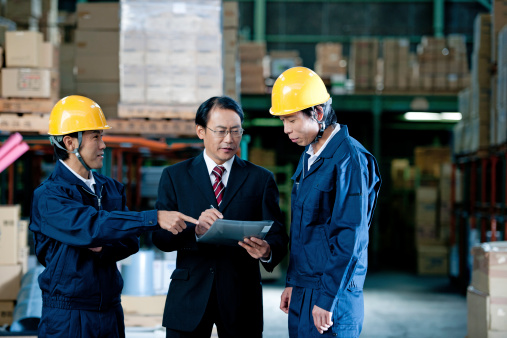 boss and two worker in a warehouse