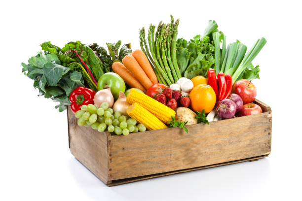 Fresh ripe vegetables and fruits in crate with olive oil metal can.