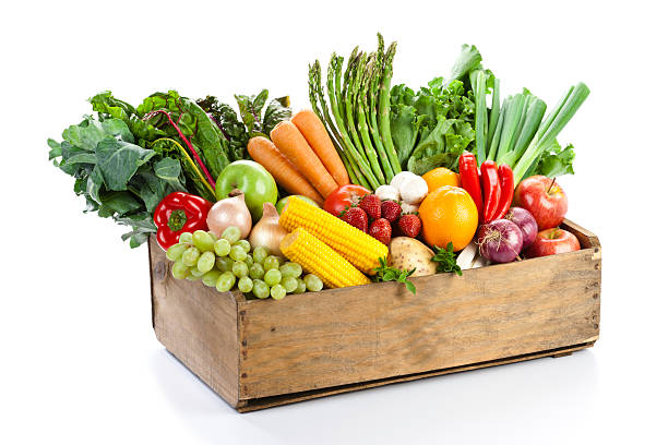 фрукты и овощи в woodden crate изолированные на белом фоне - basket of fruits стоковые фото и изображения