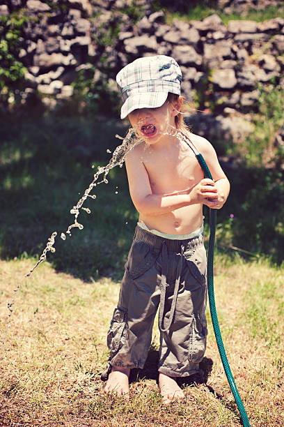 Child Drinking Water Outdoors stock photo