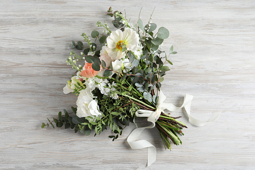 Bouquet of beautiful flowers on wooden table, top view