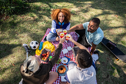 Young woman with prosthetic leg on a picnic with her friends on the public park