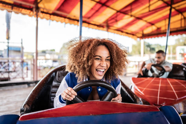 Young woman having fun riding bumper car in the amusement park